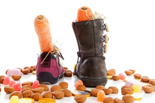 Sinterklaas, typical Dutch event with pepernoten and carrot in shoes over white background