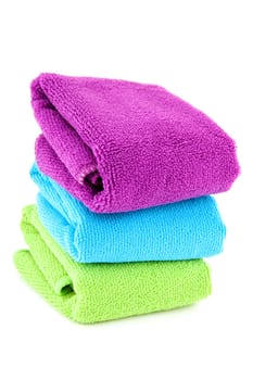 stacked colorful folded towels over white background