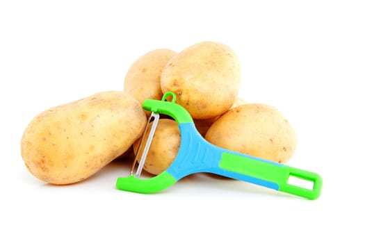 Stack of unpeeled potatoes with colorful peeling knife over white background