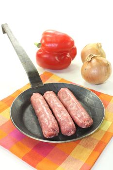 Salsiccia with vegetables in a pan on napkin on light background