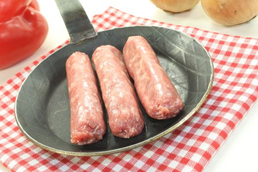 Salsiccia with vegetables in a pan on napkin on bright background