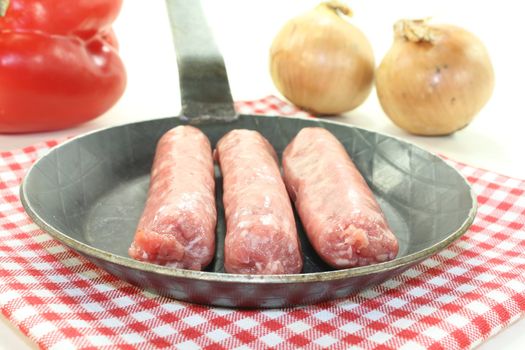 Salsiccia with peppers and onions in a pan on napkin on light background