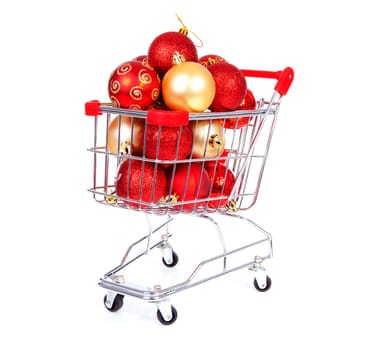 Shopping cart filled with Christmas balls over white background