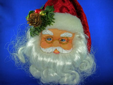 Close up of decoration of Santa Claus face with glasses on blue background