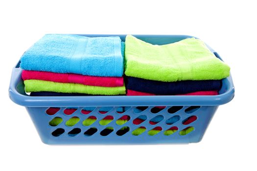 Laundry basket filled with colorful towels over white background