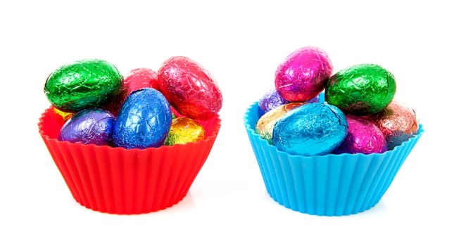 Bowls with colorful easter eggs over white background