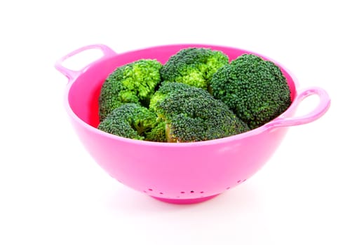 pink colander with broccoli vegetable over white background