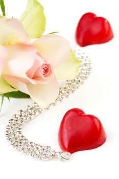 symbolic love and romance with rose, bonbon hart and diamond necklace over white background