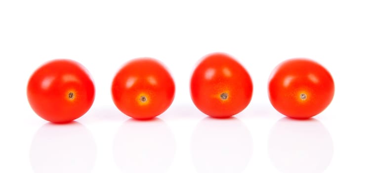 Four cherry tomatoes in a row over white background