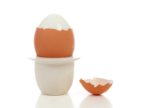 Peeled egg in holder over white background