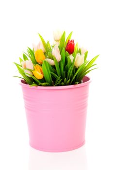 Bouquet of plastic Dutch tulips flowers in pink pot over white background