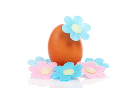 One chicken egg with pink and blue flowers over white background