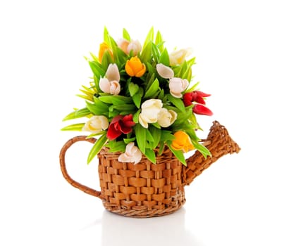 Cane watering can with plastic Dutch tulips over white background
