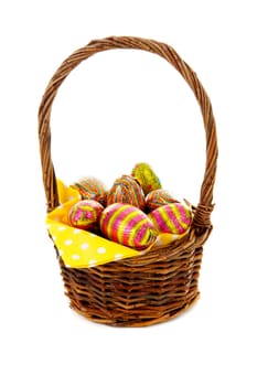 Cane basket with easter eggs over white background