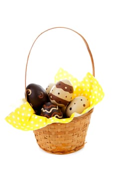 Cane basket with easter eggs over white background