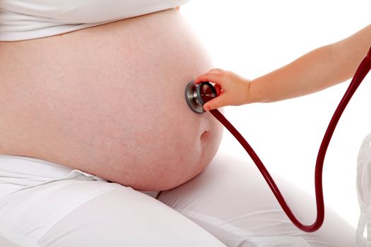 Childs hand with stethoscope on pregnant belly over white background 
