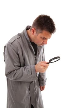 Man with raincoat is looking with magnifying glass over white background