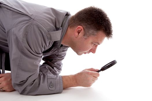 Man with raincoat is looking with magnifying glass over white background