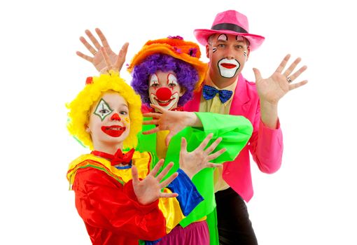 Three people dressed up as colorful funny clowns over white background