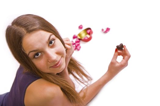Young girl holding a chocolate heart on a white background, isolated