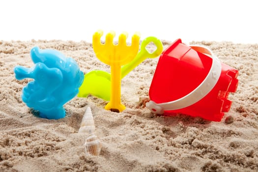 colorful plastic toys on the beach over white background