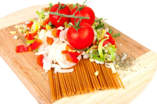 Ingredients for spaghetti on wooden cutting board over white background