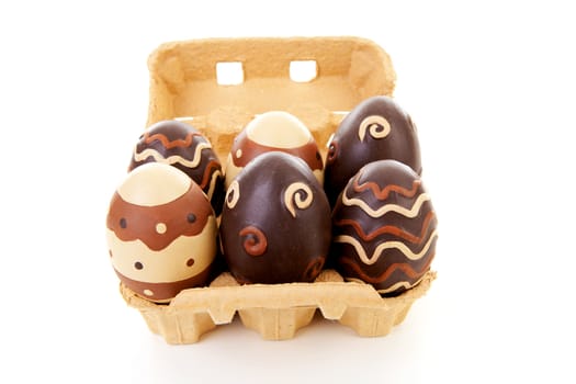 Egg carton with six decorated easter eggs over white background