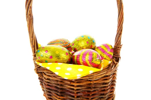 Cane basket with easter eggs in closeup over white background