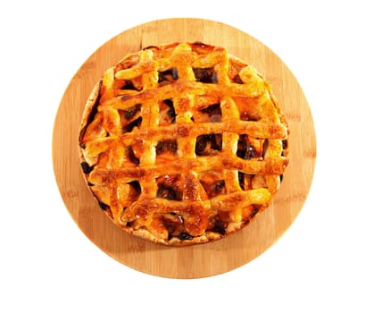 Delicious home baked apple pie on wooden cutting board over white background 
