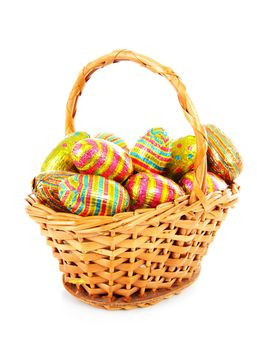 Cane basket with colorful easter eggs over white background