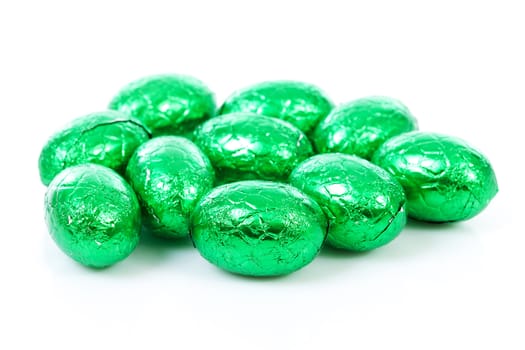 Green chocolate easter eggs in closeup over white background