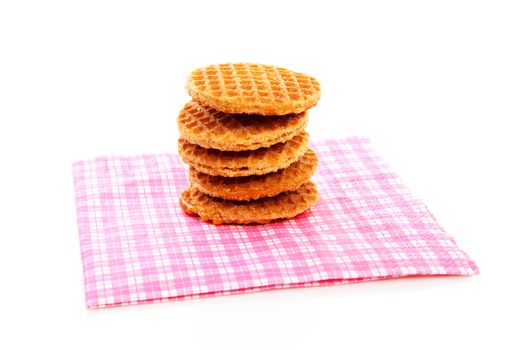 Pile of typical Dutch stroopwafels ( with syrup) on napkin over white background