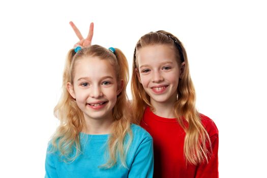 Two girls heaving fun in studio over white background