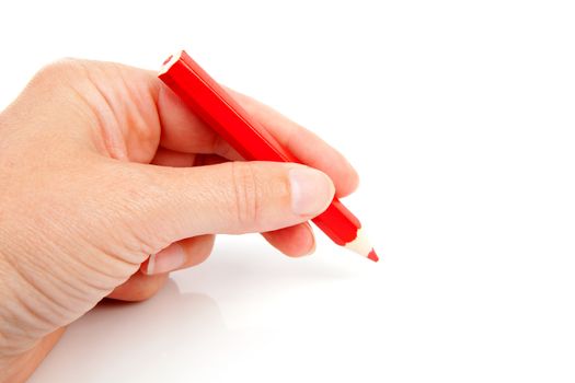 hand is holding red pencil and writes over white background