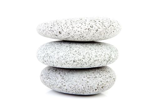 Three grey dotted stacked stones over white background