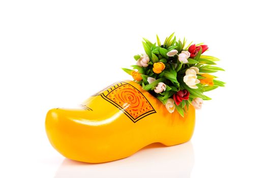 Typical Dutch clog and plastic tulips over white background