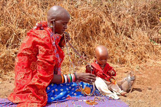 AFRICA, KENYA, MASAI MARA - JULY 2: Masai woman with child is showing and selling traditional jewelry as cultural ceremony near to Masai Mara National Park Reserve, July 2,2011,Kenya