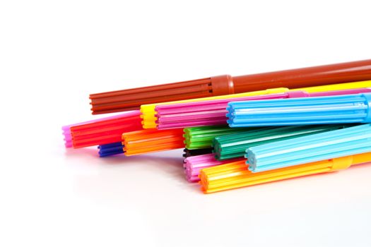 Stacked colorful markers over white background