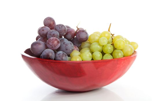 Red bowl with grapes over white background