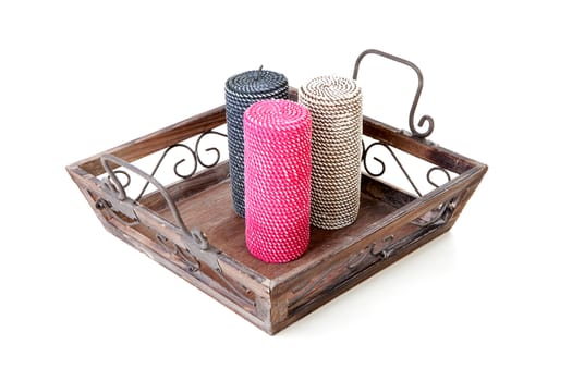 Three candles on tray over white background