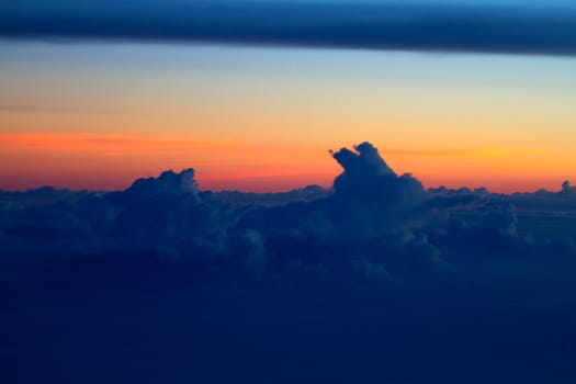 Sunset view above the clouds seen from airplane window
