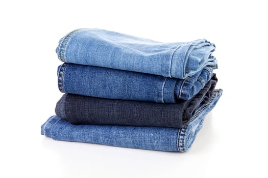 Pile of blue jeans over white background