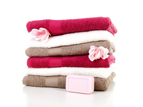 Pile of colorful towels and soap over white background