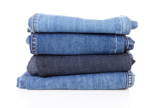Pile of blue jeans over white background
