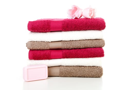 Pile of colorful towels and soap over white background