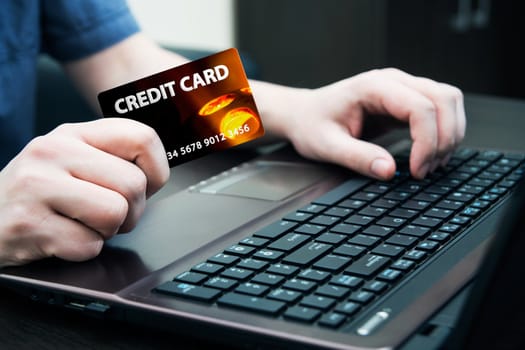 Man holding colorful credit card. Hands on computer keyboard