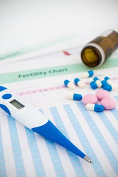 Electronic thermometer and pills on fertility chart