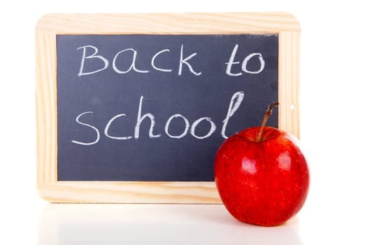 back to school written on blackboard slate and red apple over white background