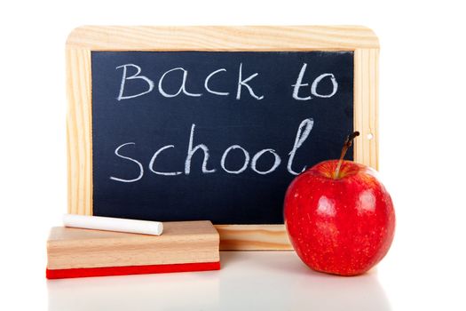 back to school: blackboard slate, wiper, chalk and apple over white background