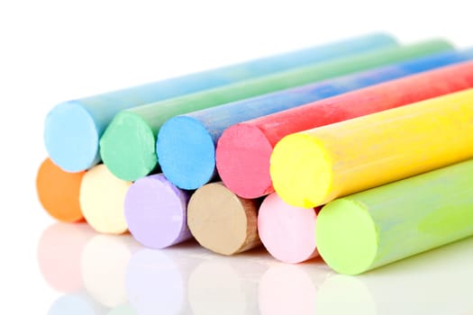 Pile of colorful chalk over white background